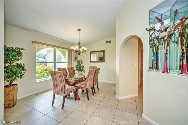 dining room featuring lofted ceiling, light tile patterned floors, and a chandelier