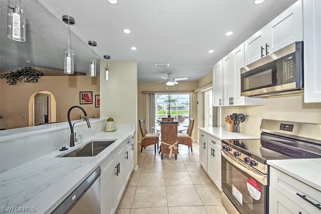 kitchen featuring white cabinetry, light stone countertops, appliances with stainless steel finishes, and sink