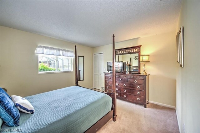 bedroom with light carpet, a closet, and a textured ceiling