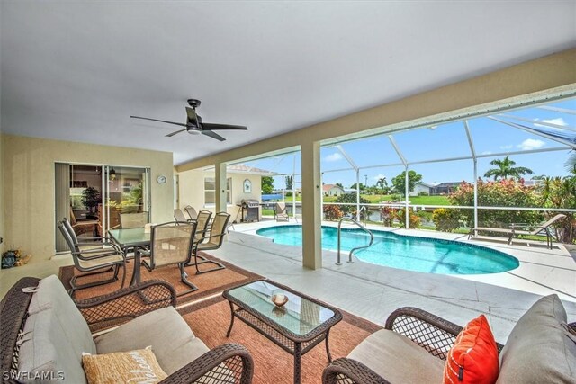 view of swimming pool featuring a lanai, an outdoor hangout area, a patio, and ceiling fan