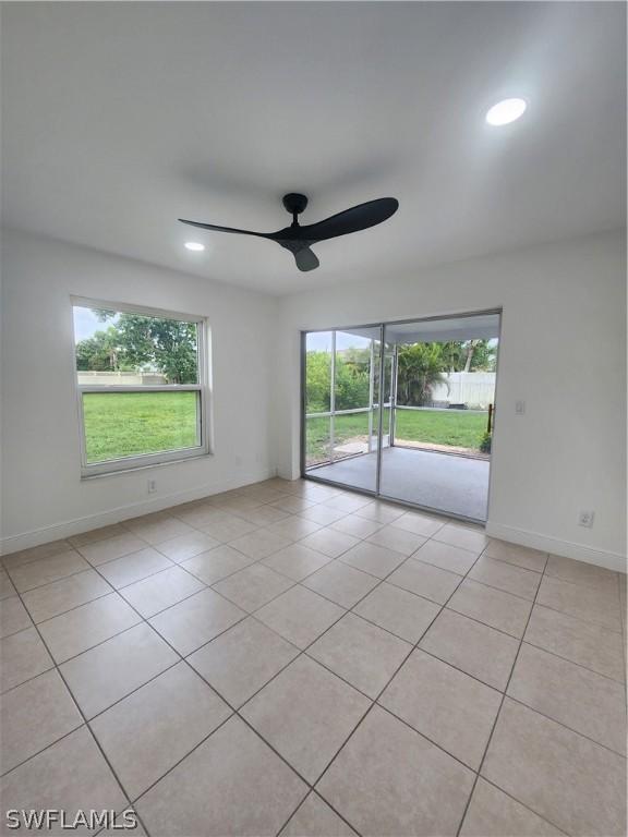 unfurnished room with light tile patterned floors and ceiling fan