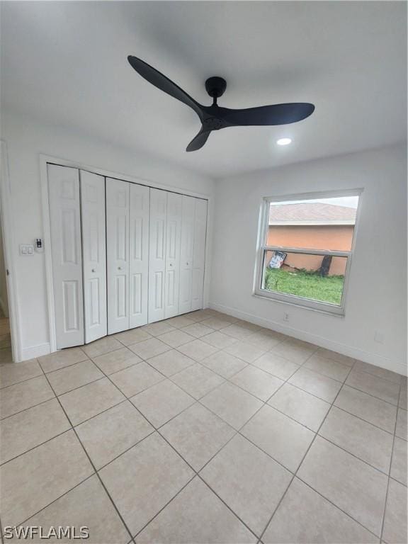 unfurnished bedroom featuring light tile patterned floors, ceiling fan, and a closet