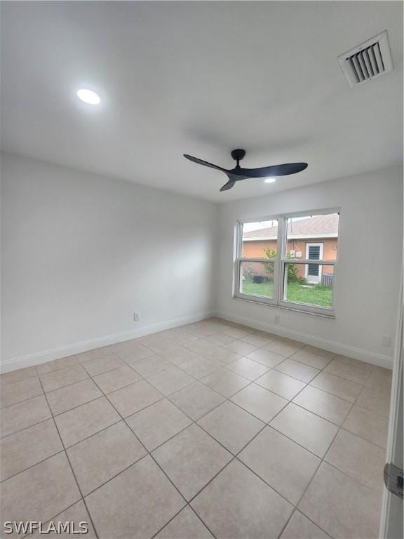 tiled empty room featuring ceiling fan