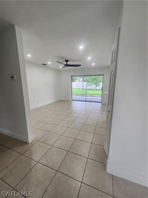 tiled spare room with ceiling fan