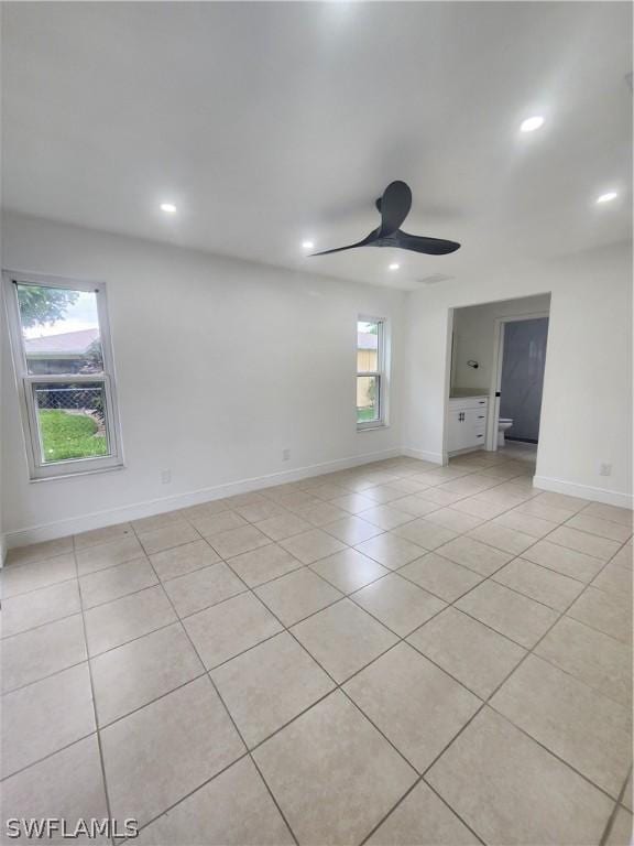 tiled spare room featuring ceiling fan