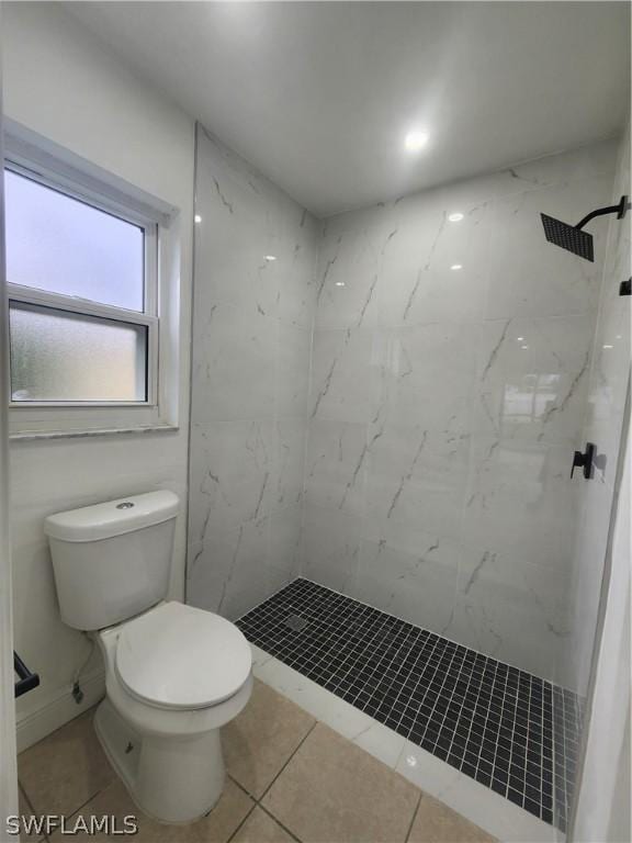 bathroom with tiled shower and toilet