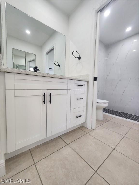 bathroom featuring tile patterned flooring, vanity, and tiled shower