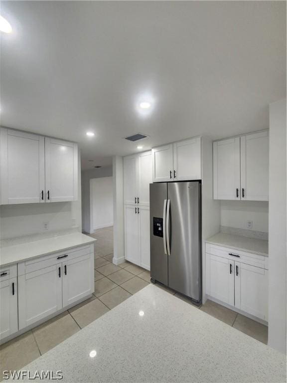 kitchen with white cabinetry, stainless steel fridge with ice dispenser, and light tile patterned floors