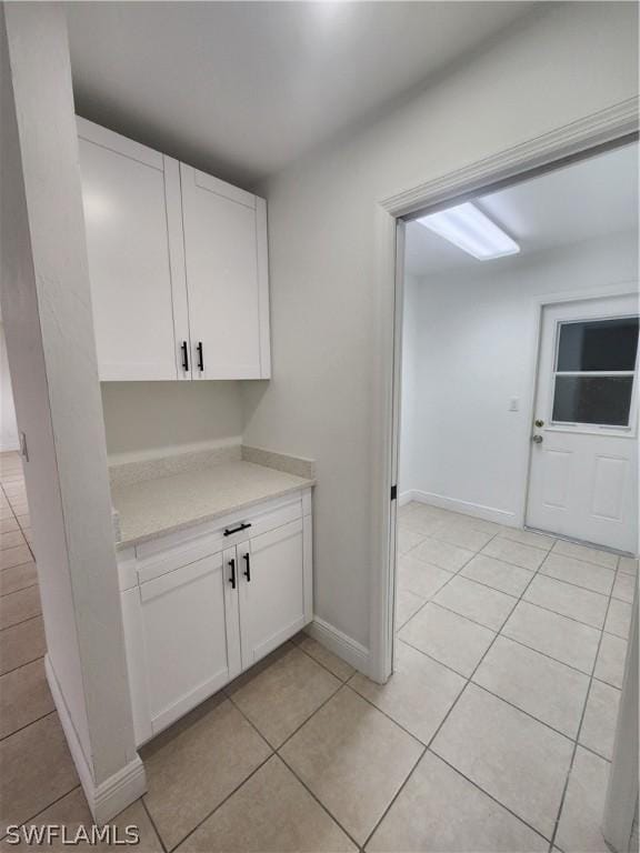 interior space with white cabinetry and light tile patterned flooring