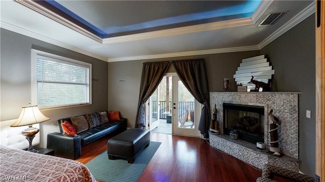 interior space with a fireplace, a raised ceiling, access to outside, and hardwood / wood-style floors