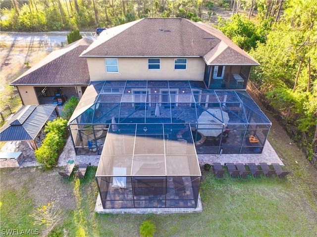 rear view of property featuring a swimming pool, a lawn, and glass enclosure