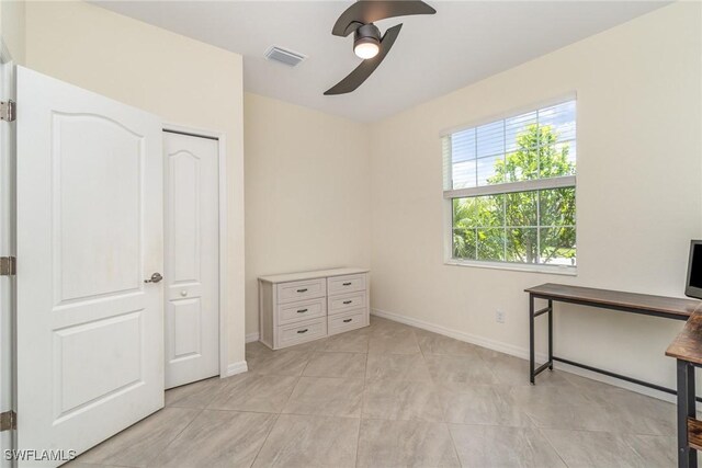 unfurnished office featuring ceiling fan and light tile patterned floors