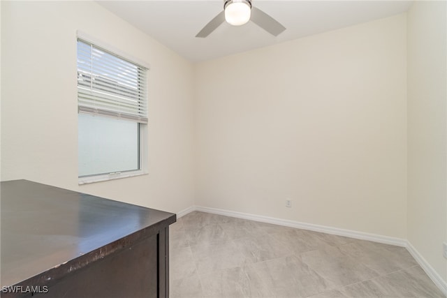 tiled spare room featuring ceiling fan