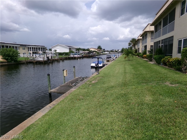 dock area with a yard and a water view