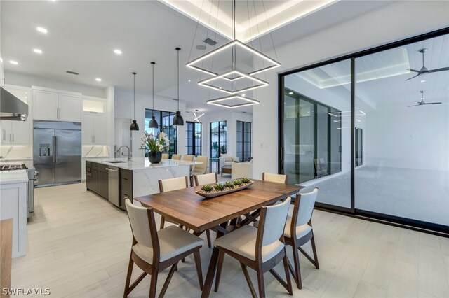 dining space with light hardwood / wood-style flooring, sink, and ceiling fan