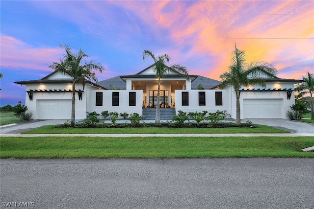 view of front of home with a garage and a lawn