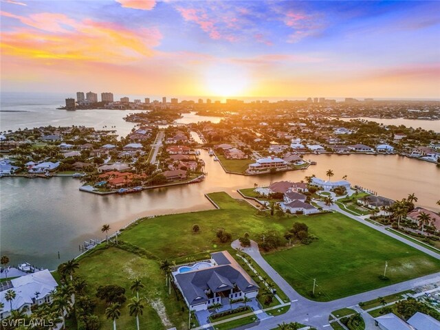 aerial view at dusk featuring a water view