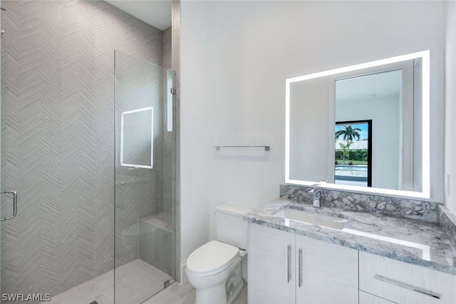 bathroom with vanity, toilet, and a shower with shower door