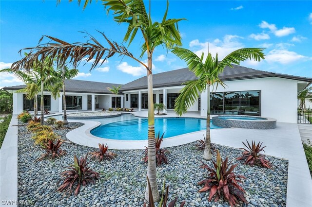 view of pool with an in ground hot tub and a patio