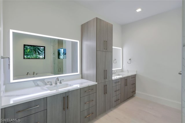 bathroom with hardwood / wood-style flooring, vanity, and walk in shower