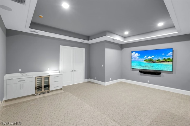 carpeted cinema featuring wine cooler and a raised ceiling