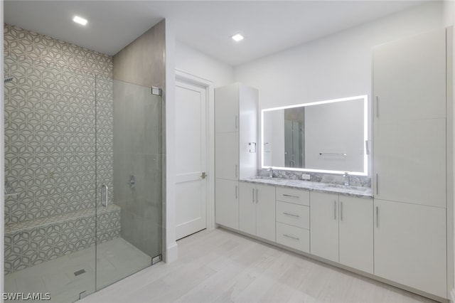 bathroom with vanity, wood-type flooring, and a shower with door