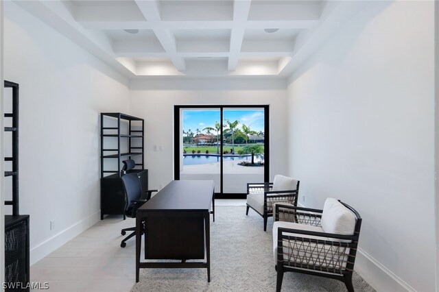 office with coffered ceiling, a water view, light wood-type flooring, beamed ceiling, and a towering ceiling