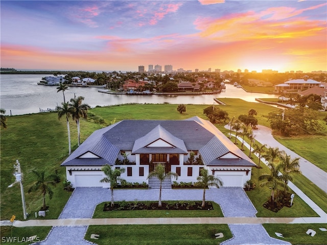 aerial view at dusk featuring a water view