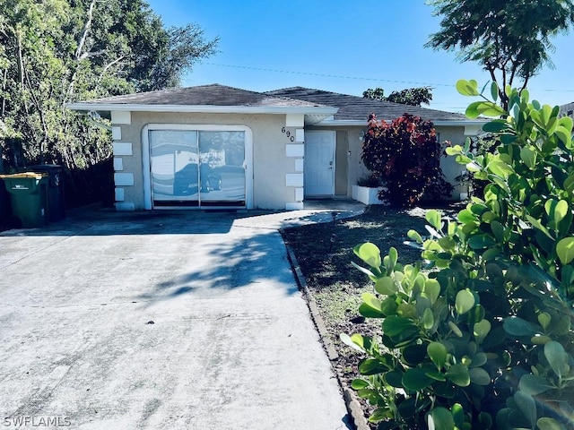 ranch-style home with concrete driveway and stucco siding