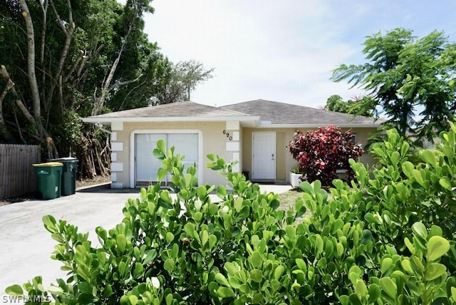 view of front facade featuring a garage, concrete driveway, and stucco siding