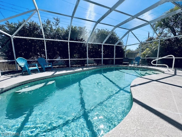 pool with glass enclosure and a patio