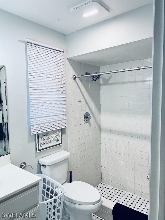 full bath featuring toilet, a shower stall, and vanity