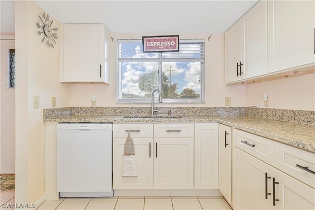 kitchen with white dishwasher, white cabinets, sink, light tile patterned flooring, and light stone counters