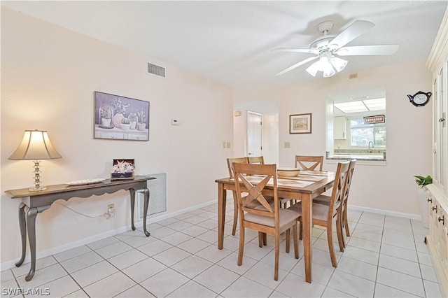 tiled dining room featuring ceiling fan and sink