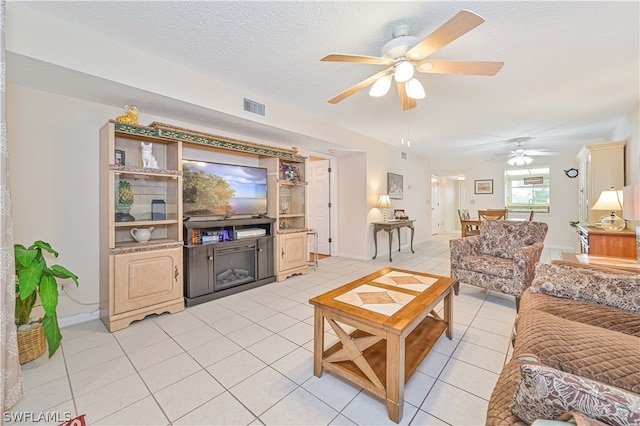 tiled living room featuring ceiling fan and a textured ceiling