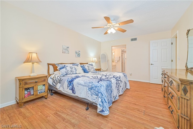 bedroom featuring ceiling fan, light wood-type flooring, and ensuite bathroom