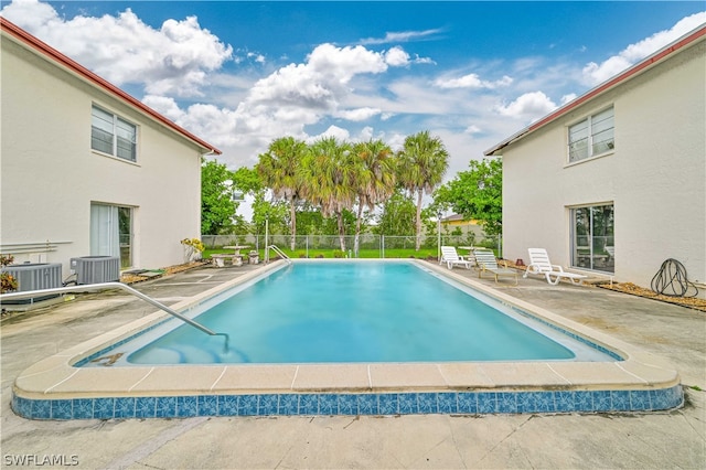 view of pool with a patio area and central air condition unit