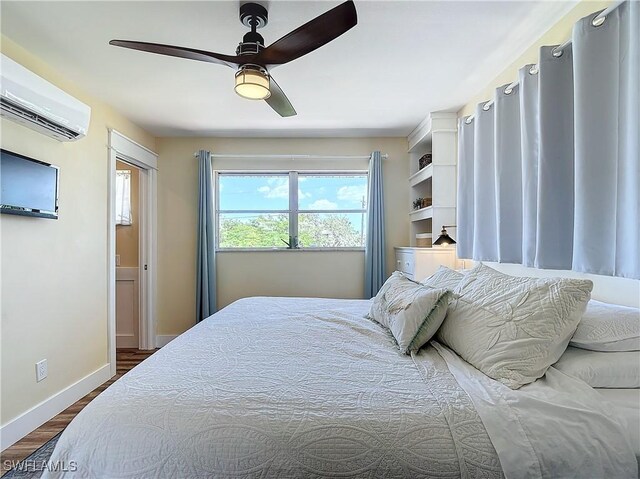 bedroom with ceiling fan, hardwood / wood-style floors, and a wall mounted air conditioner