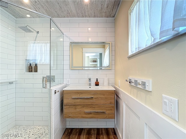 bathroom featuring an enclosed shower, hardwood / wood-style flooring, tile walls, and vanity