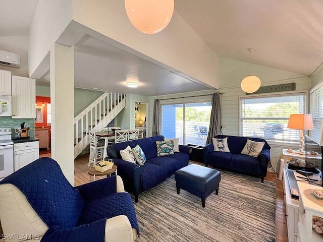 living room with an AC wall unit, hardwood / wood-style flooring, and high vaulted ceiling