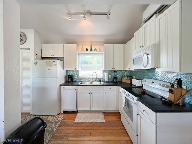 kitchen with decorative backsplash, rail lighting, white appliances, sink, and light hardwood / wood-style floors