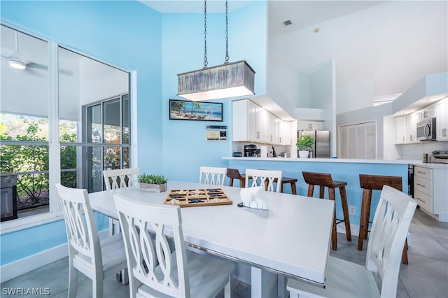 dining area featuring a high ceiling and ceiling fan