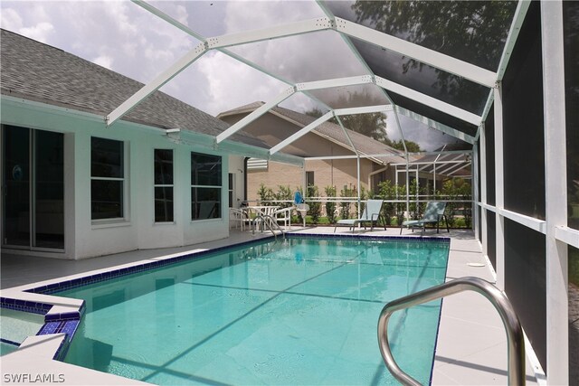 view of swimming pool featuring glass enclosure