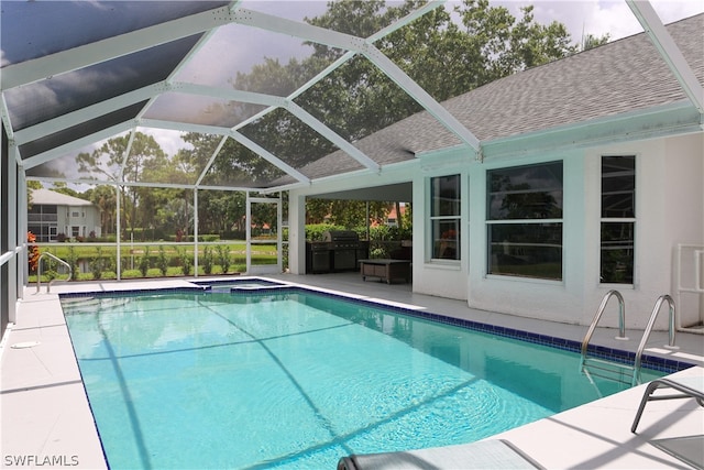 view of swimming pool with an in ground hot tub, glass enclosure, and a patio