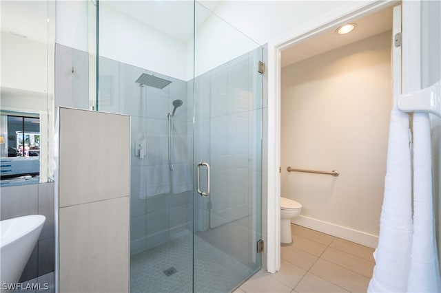 bathroom featuring toilet, tile patterned flooring, and a shower with shower door