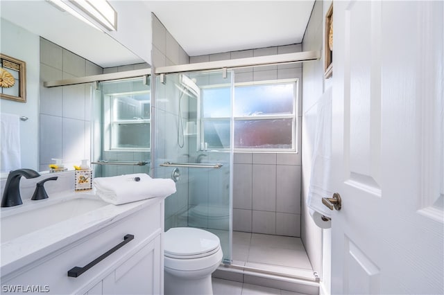 bathroom featuring a shower with door, vanity, and toilet