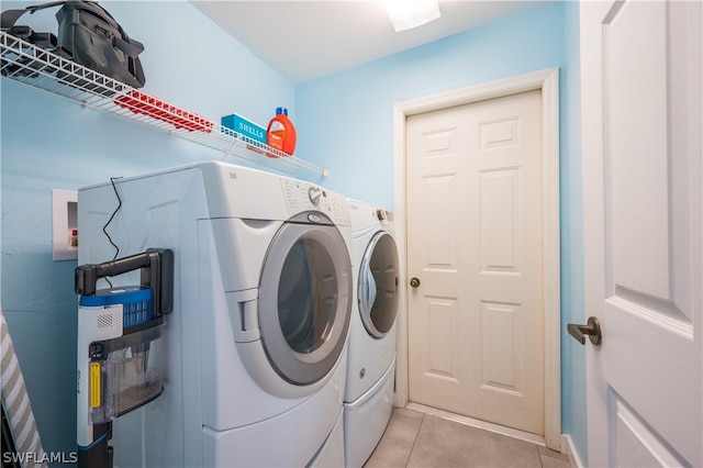 laundry room featuring washing machine and dryer and light tile patterned floors