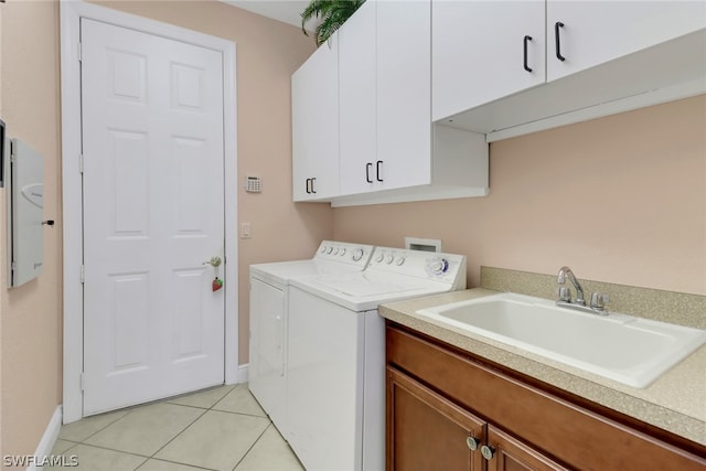 laundry room with cabinets, washer and clothes dryer, sink, and light tile patterned floors