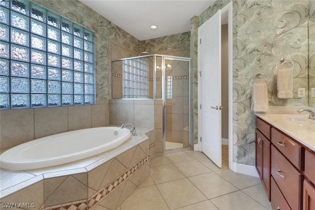 bathroom with tile patterned flooring, vanity, and plus walk in shower