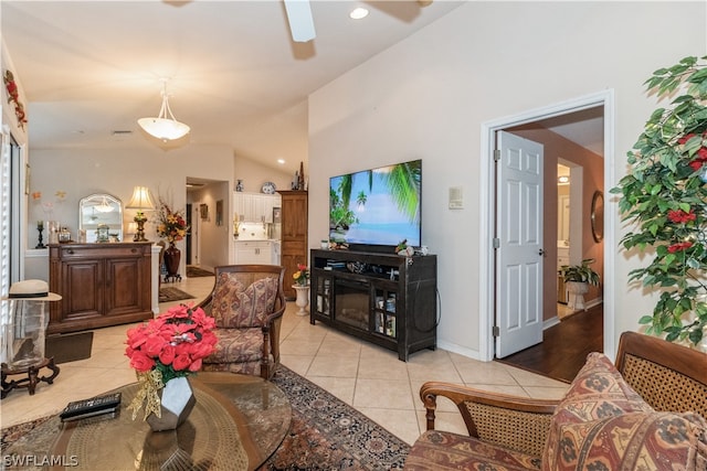 living room with light tile patterned floors, ceiling fan, and vaulted ceiling